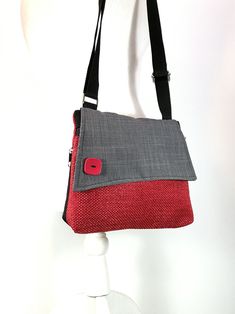 a red and gray purse sitting on top of a white mannequin