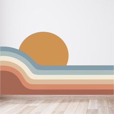 the sun is setting over an ocean wave wall decal in a room with hardwood floors