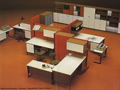 an office with cubicles, desks and filing cabinets in orange carpeted room