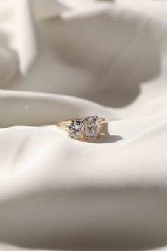 two diamond rings sitting on top of white fabric