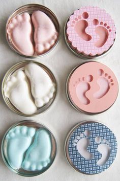 six baby footprints and feet in small tins