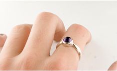 "A simple ring with a bright purple natural amethyst cabochon that is bezel set in sterling silver. The amethyst, mined in Brazil, is 5mm round (about 1/4\" inch). A minimal and elegant design durable enough for everyday wear. The sterling silver is hypoallergenic nickel free. Size adjustments are available upon request- just message us! Our jewelry was designed and made by Jan Palombo of Great Falls Metalworks who has been making jewelry in the USA since 1968. The collection in this shop is of Minimalist Amethyst Gemstone Ring, Minimalist Silver Amethyst Ring, Minimalist Amethyst Ring For Anniversary, Purple Sterling Silver Birthstone Ring With Round Band, Minimalist Purple Sterling Silver Rings, Minimalist Purple Gemstone Birthstone Ring, Minimalist Purple Gemstone Rings, Minimalist Purple Birthstone Ring, Sterling Silver Amethyst Ring With Bezel Setting For Promise