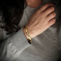 a close up of a person wearing a gold bracelet