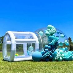 an inflatable pool with bubbles on the grass next to a large bubble machine