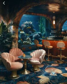 an underwater bar with pink chairs and gold stools in front of the fish tank