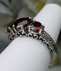 "Red Garnet Cubic Zirconia Ring Description Hearts Design#143 Made To Order This is a lovely Edwardian inspired ring in solid sterling silver. The gorgeous filigree ring is set with 3 heart cut simulated/Man-made garnet red CZ gemstones. The 2 smaller gems are 5mm in diameter, and the center one is 7mm in diameter. Notice the amazing etched band... The ring sits 1/4th\" (7mm) off the finger. The quality of the silver and gemstones are simply breathtaking... a ring that will last for countless ye Star Ruby Ring, Mystic Fire Topaz, Hearts Design, Order Design, Red Gemstones, Red Band, Sterling Silver Filigree, Cubic Zirconia Rings, Mystic Topaz