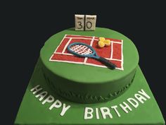 a green birthday cake with a tennis racket on it's side and the number 30