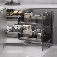 an open cabinet in the middle of a kitchen filled with dishes and utensils