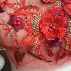 the back of a dress with red flowers on it