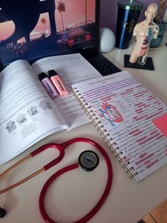 an open book sitting on top of a desk next to a stethoscope