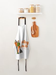 an apron hanging on the wall next to a cutting board