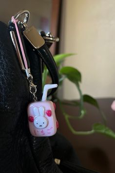 a keychain with a cartoon character on it is hanging from a black leather purse