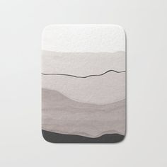 a bath mat with an abstract design on the front and back of it, in grey tones