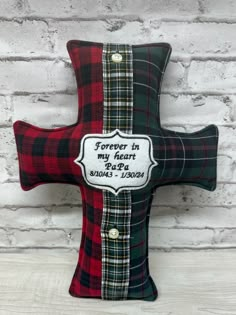 a red and black plaid pillow with a cross on it