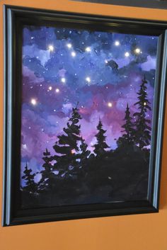 the painting is hanging on the wall in front of the orange wall and there are stars above the trees