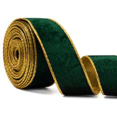 a roll of green and gold velvet ribbon on a white background with clippings