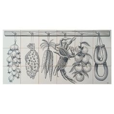 a tile mural with fruit and vegetables hanging from it's hooks on the wall