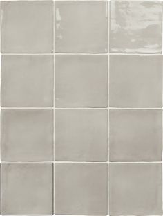 a white tile wall with several square tiles on the bottom and one in the middle