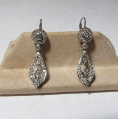 The pair of earrings are marked 14k and solid white gold. Together they weigh 4.5 grams. The earring are for pierced ears and dangle to 1 1/4" long . Together the earrings hold a total of 48 round natural diamonds with an approx total weight of .25 cts. The diamonds are white and range from SI3 to I2. Fine Jewelry Diamond Chandelier Earrings, Diamond Chandelier Earrings For Pierced Ears, Classic Diamond White Pierced Earrings, Formal Diamond Earrings, Pierced, Formal Pierced Diamond Earrings, Classic Brilliant Cut Chandelier Earrings For Anniversary, White Gold Chandelier Earrings For Formal Occasions, Classic White Gold Diamond Chandelier Earrings, Classic Drop Chandelier Earrings With Diamond Accents