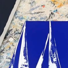 the sailboat is painted blue and white on the paper with paint splatters