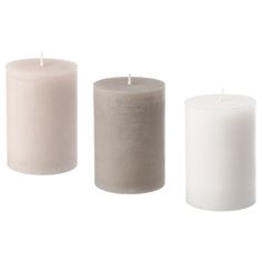 three different types of white candles on a white background