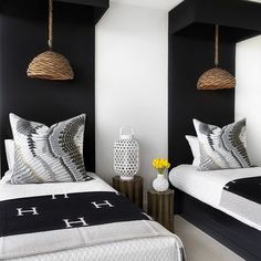 two beds in a room with black and white decor