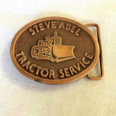 Vintage Copper Tone finished Steve Abel Tractor Service Brass Belt Buckle. It was manufactured by Hit Line Buckles, U.S.A., and limited to 100 buckles. The buckle measures approx. 2-7/8" long by 2-5/16" wide and will accept a 1-3/4" wide belt. Please examine the attached photos, they describe this listing better than any words. If you can see only one photo, click the link below to the FULL description for multiple photos. Vintage Steve Abel Tractor Service Brass Belt Buckle Vintage Steve Abel T Vintage Brass Buckle Belt Buckles Collectible, Vintage Gold Belt Buckles For Collectors, Vintage Brown Belt Buckle With Antique Detail, Vintage Brown Belt Buckles With Brass Buckle, Retro Vintage Brown Belt Buckle With Antique Detail, Antique Belt Buckles For Collectors, Brass Belt, Brass Belt Buckles, Photos Vintage