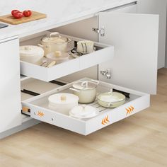 an open drawer in a kitchen with pots and pans on the bottom shelf,