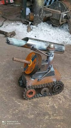 an old machine that is sitting on the ground in front of some snow covered ground