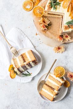 two slices of cake on plates with oranges and flowers in the background next to them