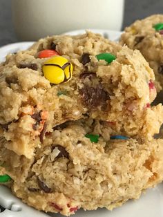 two cookies with m & m candies on them and a cup of coffee in the background