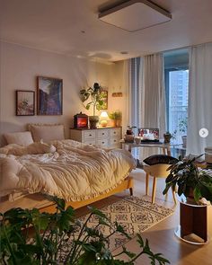 a bed sitting in the middle of a living room next to a potted plant