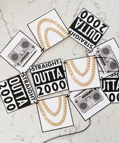 some stickers that are sitting on top of a marble table with gold chains around them