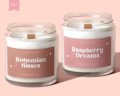 two candles with labels on them sitting side by side in front of a pink background