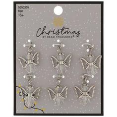 six silver angel charms with pearls on the bottom and an image of a christmas tree in the background