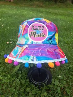 Its more than music bucket hat! Perfect for a show or festival! with or without the trim. Headbanger approved! Size: Medium *Each item is handmade and made-to-order so there may be slight varients between each hat in terms of pattern position, charm position, pompoms, etc. Fun Carnival Costume Hats And Headpieces, Fun Festival Costume Hats And Headpieces, Fun Cotton Festival Hats, Adjustable Summer Rave Hats, Summer Rave Festival Hats, Fun Snapback Hats For Music Festival, Adjustable Rave Hats For Festivals, Multicolor Hats For Music Festival, Fun Brimmed Bucket Hat For Festivals