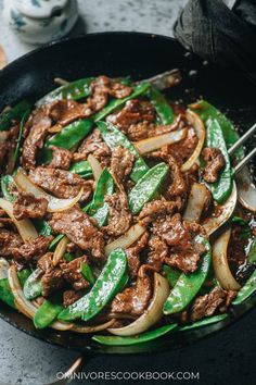 beef and bell peppers in a skillet with chopsticks on the side, ready to be eaten