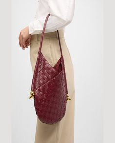 "Find BOTTEGA VENETA Small Solstice Shoulder Bag on Editorialist. The Bottega Veneta \"Solstice\" shoulder bag is crafted from intrecciato lambskin leather. The bag features a rolled shoulder strap with metal knots on the sides. The bag has an open top with a self-tie closure and an interior leashed zip pouch bag. The bag is lined with leather and measures approximately 11.8\"H x 10.2\"W x 0.8\"D. The bag is made in Italy." Luxury Handheld Hobo Bag For Office, Formal Tote Shoulder Bag With Woven Leather, Formal Woven Leather Tote Shoulder Bag, Luxury Handheld Bucket Bag For Office, Designer Bucket Bag With Leather Handles For Office, Formal Intrecciato Weave Shoulder Tote Bag, Elegant Woven Leather Bucket Bag, Elegant Woven Leather Tote Shoulder Bag, Elegant Woven Leather Hobo Bag For Travel