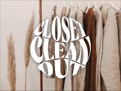 the logo for closet clean out hangs on a rack in front of several coats and sweaters