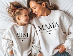 Mama sweatshirt, Mini sweatshirt, personalized mom sweater, Mama est sweatshirt, Mom Gift, Personalization, embroidered mama sweatshirt You need both sweatshirts for the partner look. ♥PRODUCTION TIME: 1-5 days (usually 2-3 days) ♥SHIPPING TIME: 2-5 days (usually 3 days) ♥PRODUCT DESCRIPTION: Ideal for any occasion, this sweatshirt offers ultimate comfort with a blend of polyester and cotton for a soft feel and vibrant design. * Fabric: Polyester and cotton blend (fiber content may vary by color) * Fit: Classic fit with a seamless body, offering a clean, streamlined look * Collar: Ribbed knit collar with spandex for added stretch and shape retention * Durability: Made with MVS Air Spinning technology for reduced pilling and improved durability * Design: Smooth printing surface for fresh an Mama And Me Sweatshirts, Mama Sweatshirt With Baby Clothes, Momma And Mini Sweatshirts, Momma And Mini Shirt, Mama Mini Sweatshirt, Mama Sweatshirt With Names On Sleeve, Mom Sweater, Mama Sweatshirt, Mom Sweatshirt