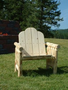 a wooden chair sitting on top of a lush green field