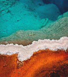 an aerial view of the water and land in the ocean with orange, blue and green colors