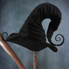 a black witches hat on top of a wooden stick