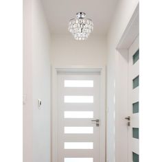 a white door with a crystal chandelier hanging from it's side wall