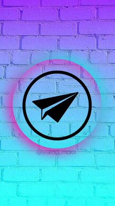 an image of a paper airplane in a circle on a brick wall with blue and purple hues