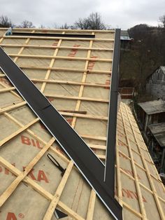 the roof of a house being built with wood framing and metal bars on it's sides