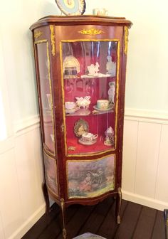 an old china cabinet with many items on it