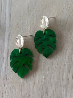 Marbled green Monstera leaf earrings. Pick between gold or silver disk studs attached to the monstera leaf. I make each pair with love and aloha. The earring hooks and studs are all stainless steel hypoallergenic. The perfect pair of earring for any house plant lover out there. Take these earrings on your next tropical vacation! Comes packaged on a earring card in a natural cotton bag, ready for gifting. Measurements- Total length- 2 inches To preserve your jewelry- take off before working out, coming in contact with water or sleeping. 🌺Every piece is handmade with aloha!  Please understand, there may be slight imperfections. This just makes each piece unique!  🌺Colors may differ slightly because of different monitor screens.  🌺 The pictures are of the exact item you will be receiving. Monstera Leaf Earrings, Tropical Earrings, Earrings Golden, Earring Card, Golden Earrings, Earring Cards, House Plant, Tropical Vacation, Monstera Leaf