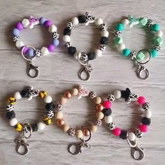 several bracelets with charms on them sitting on a table