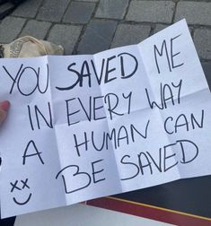 someone holding up some paper with writing on it that says you saved me in every way a human can be saved